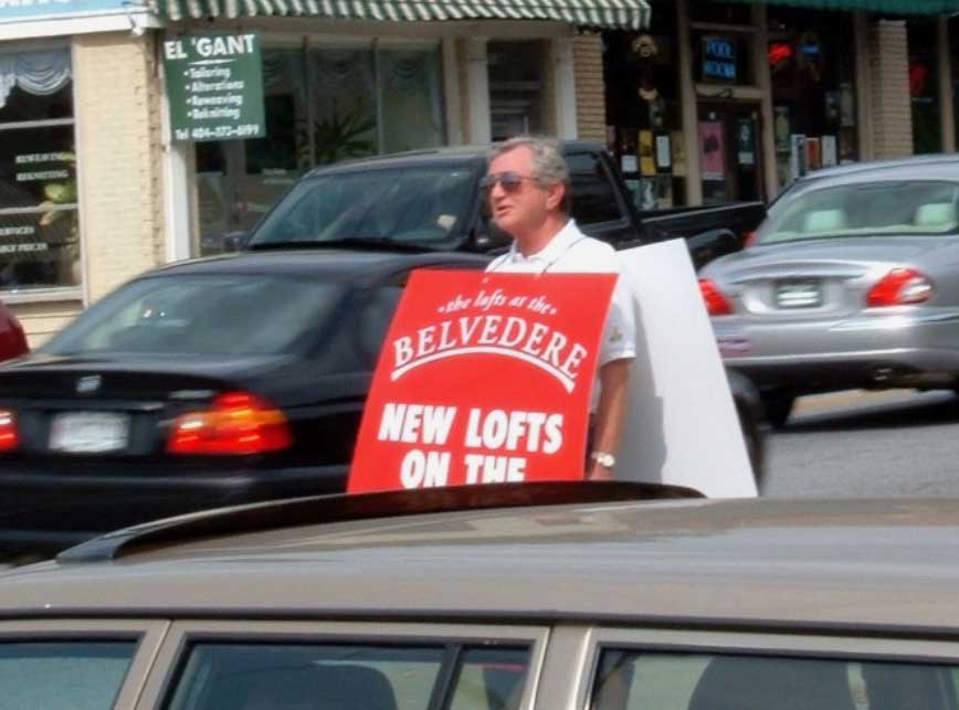 Man holding a sandwich sign advertisement