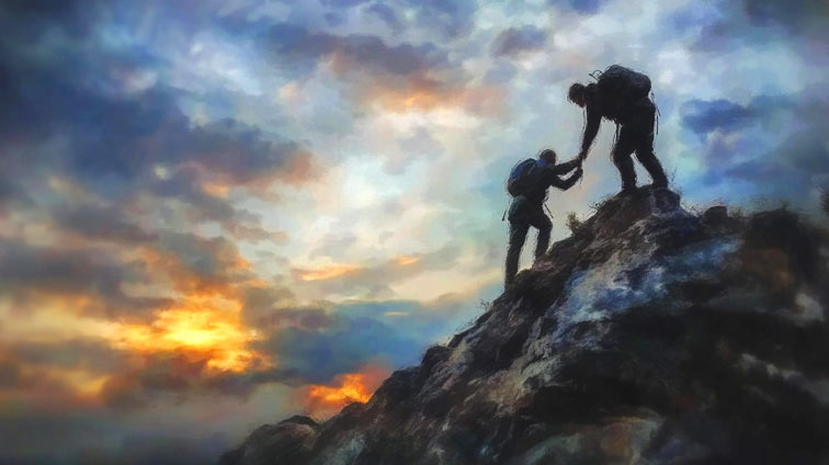 one person helping another person climb a mountain